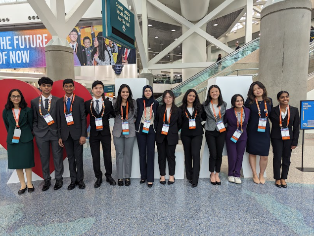 12 individuals posing at the entrance of the International Science & Engineering Fair